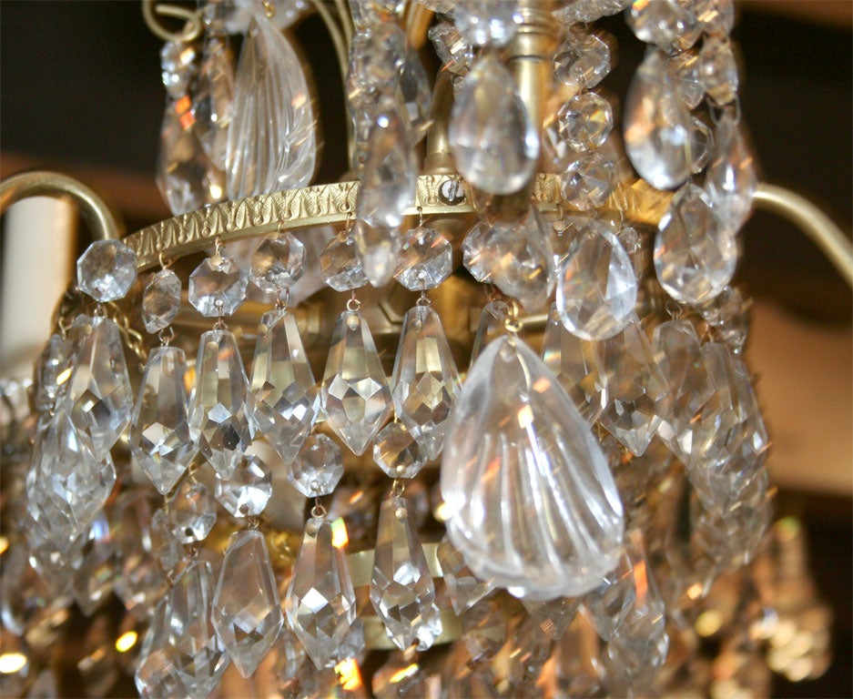 A French gilt bronze chandelier with crystals and rock crystal, circa 1920.