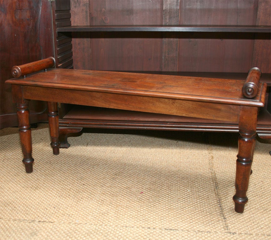 English William IV mahogany hall bench with bolster-turned ends on turned tapered legs.