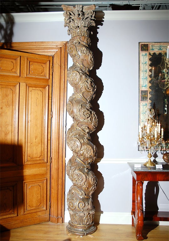 Each spirally twisted shaft carved with repeating scrolling foliage enclosing flowerheads, supporting an acanthus carved Corinthian capital and resting on a circular cavetto plinth.