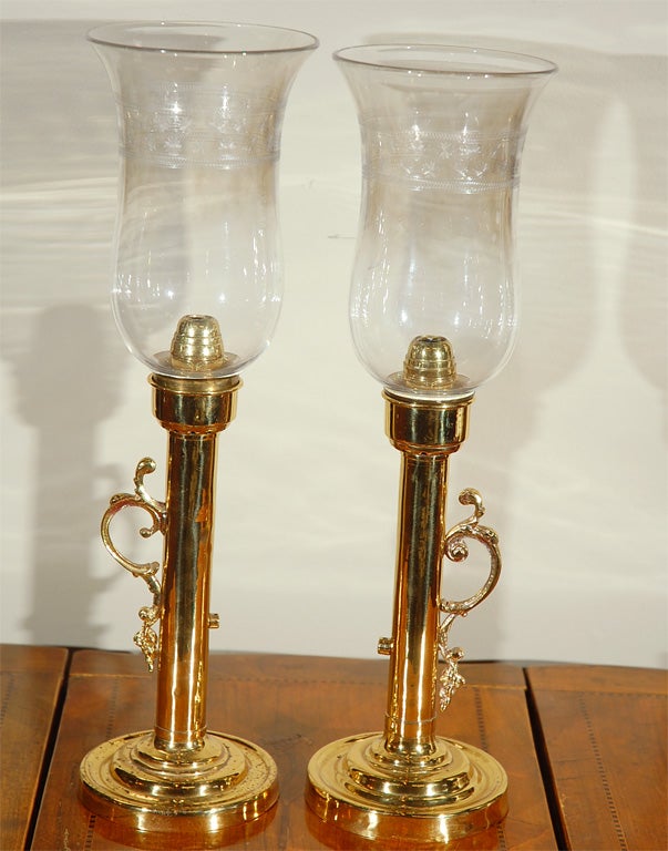 Pair of 19th century brass hurricane candleholders with etched glass globes and original spring pushups.  Priced as a pair.