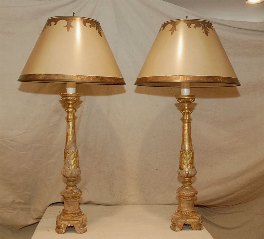 Traditional Italian altersticks are carved, gessoed, and gilded in this simple and elegant style. Note the popular pineapple motif carving on the shaft of the candlestick.  The shades take their inspiration from the carving on the base and repeat