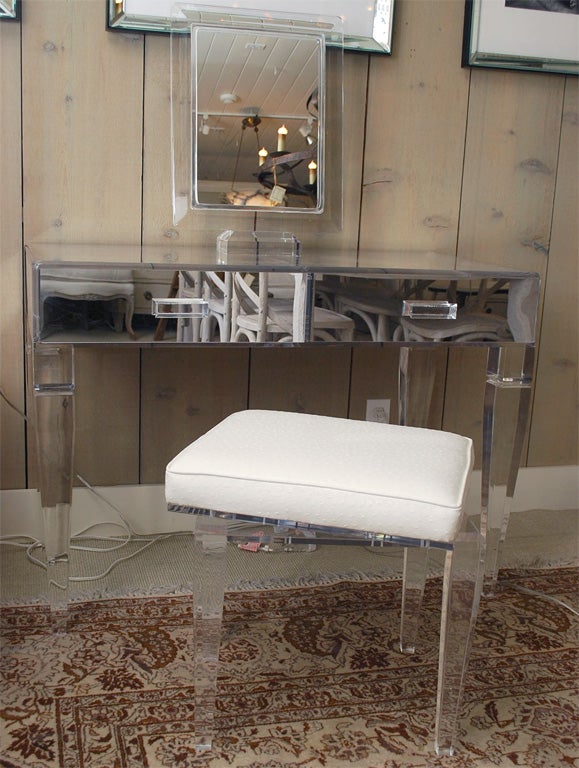 Lucite 2-drawer dressing table designed by Donna Parker with a lucite mirror and a lucite stool that swivels covered in faux ostrich also designed by Donna Parker. The dressing table can be purchased separately for $3900