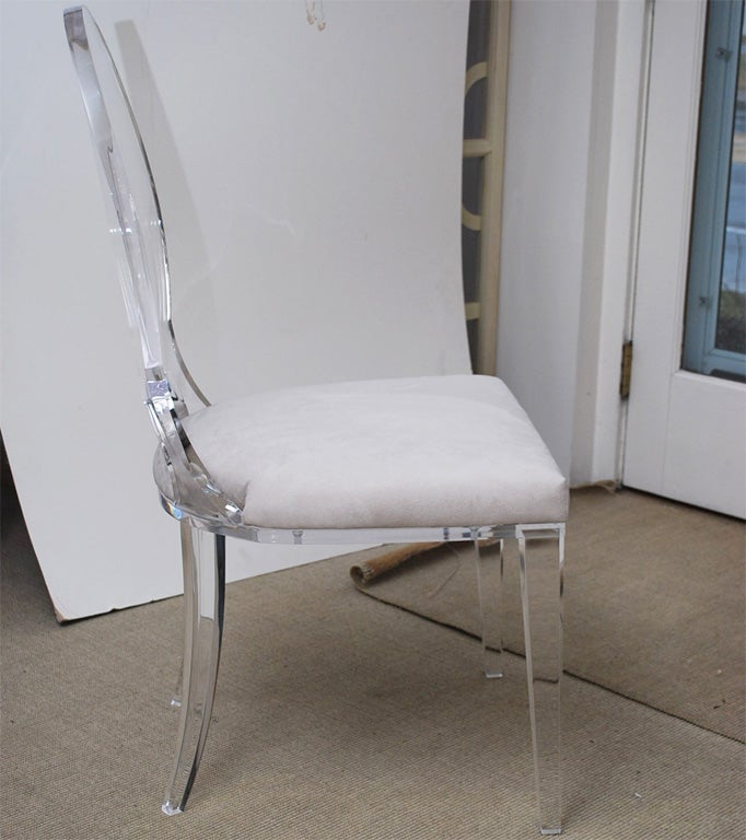 Well made and extremely sturdy lucite dining chair upholstered in off-white ultrasuede. There are 8 available.