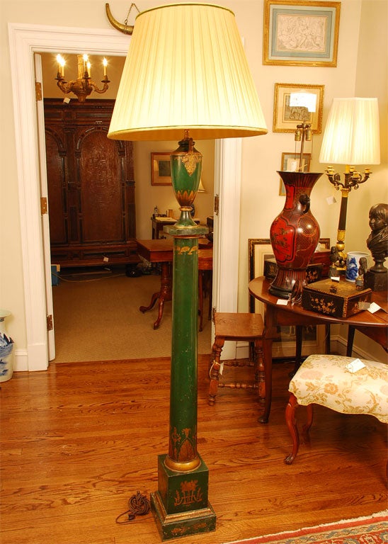 Con una decoración dorada de follaje estilizado, la urna flanqueada por cisnes, rematada por una pantalla de seda.