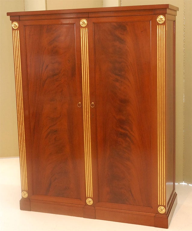 Incredible flame mahogany and gilt finished gentleman's wardrobe from Maison Jansen.  The piece is marked Jansen.  Please see additional photos for interior outfitting.