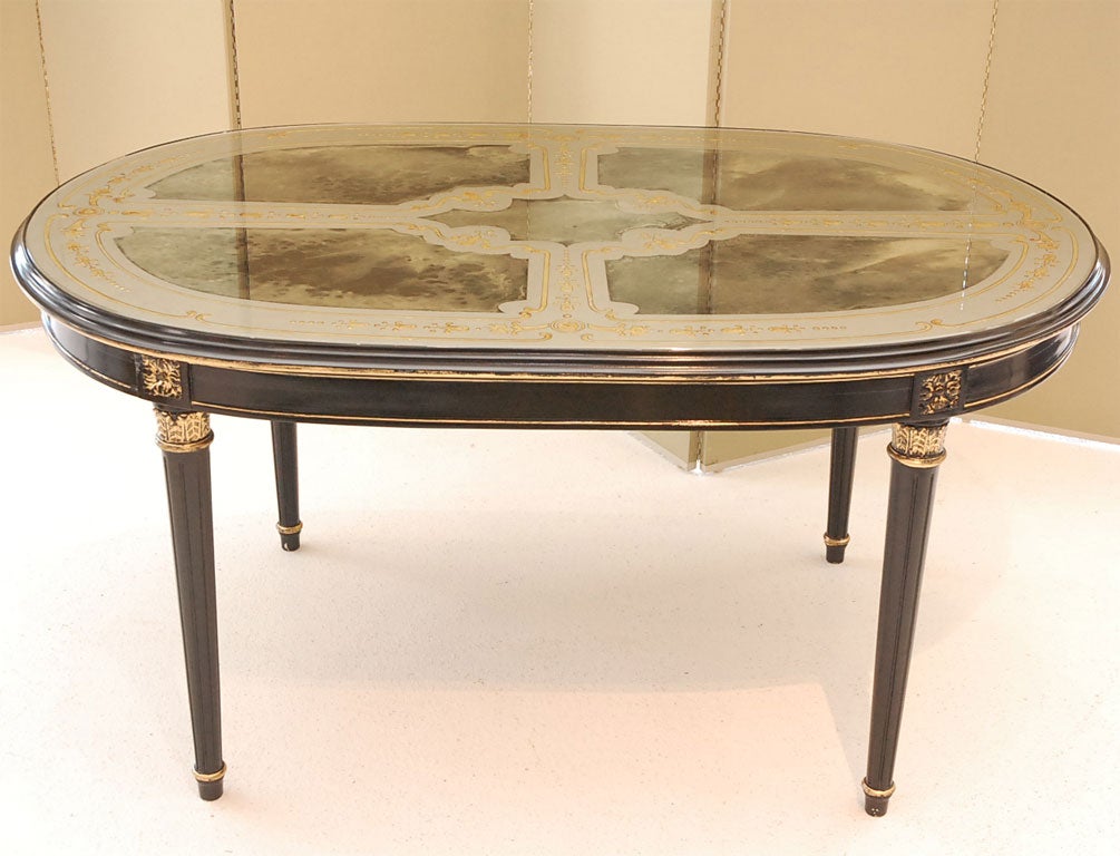 A Racetrack Oval Dining Table with beautiful eglomise-decorated mirror top, and gilt/ebonized wood framework.  In the Louis XVI style, signed JANSEN.