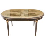 An Ebonized, Gilt, and Eglomise Oval Dining Table signed Jansen