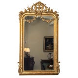 Antique French giltwood mirror w/floral swags and crest.
