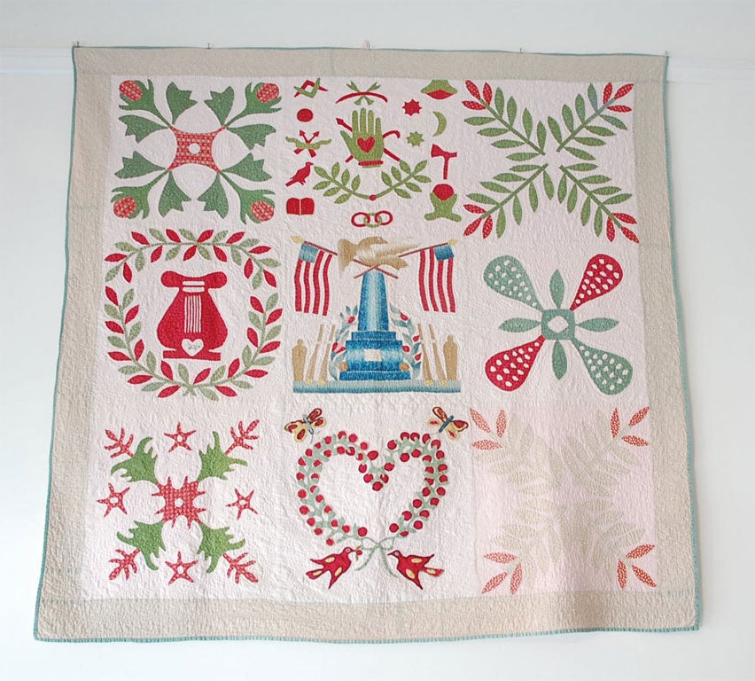 RARE AND UNUSUAL MOUNTED 19TH CENTURY ALBUM CRIB QUILT - CENTER BLOCK IS BALTIMORE MONUMENT WITH EAGLE AND CROSS FLAGS.  ALSO RARE TOP CENTER BLOCK HAS HEART IN HAND APPLIQUE ALONG WITH MASONIC SIGNS.  THIS RARE BEAUTY ALSO HAS A SIGNATURE IN THE