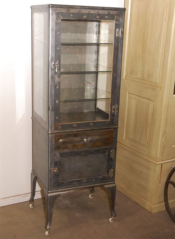 An interesting medical cabinet having one glazed door and one drawer over a solid door. The cabinet is raised and stands on four out-turned legs ending on porcelain wheels. The cabinet is a good size standing nearly six foot and is well constructed.
