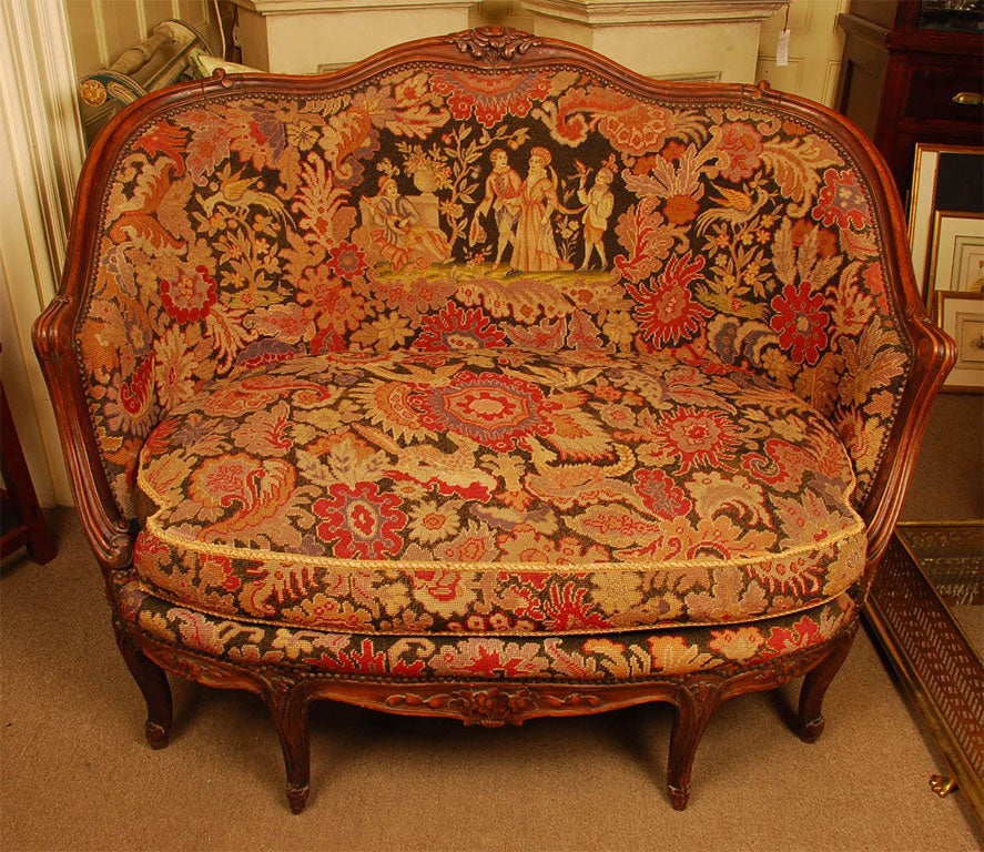 Louis XV style hand carved walnut canape with needlepoint upholstery.  The figurals are in petit point.