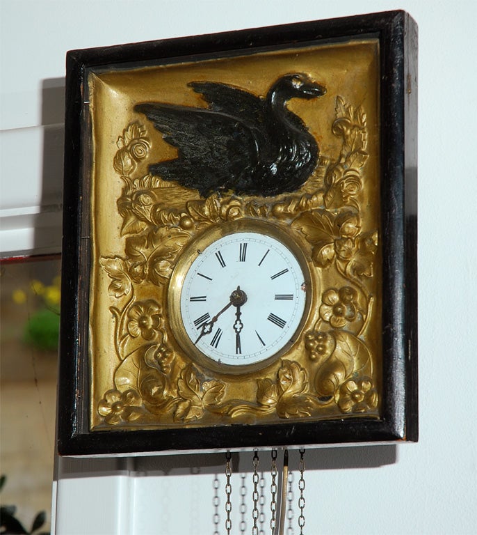 An attractive wall clock from Germany or central Europe, circa 1880's, having an enameled dial which is set into an embossed face plate. A game bird is picked out in black and sits atop flora and fauna which surrounds the clock. The clock has a