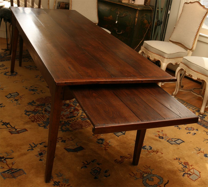 This country French table has beautifully delicate proportions for such a large table. There is a pull out breadboard at one end and a large drawer at the other end.