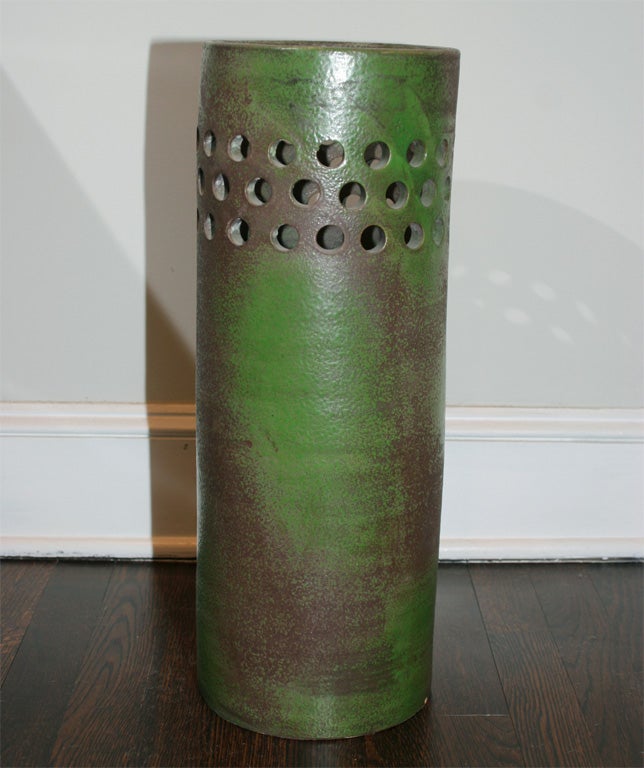 Ceramic umbrella stand, roughly-formed with perforated sides, apple green over deep brown glaze.