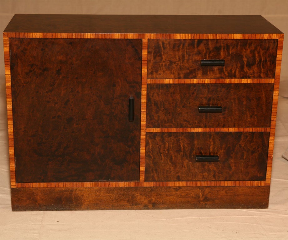 Small burl veneered chest with three drawers on one side and cupboard on the other.