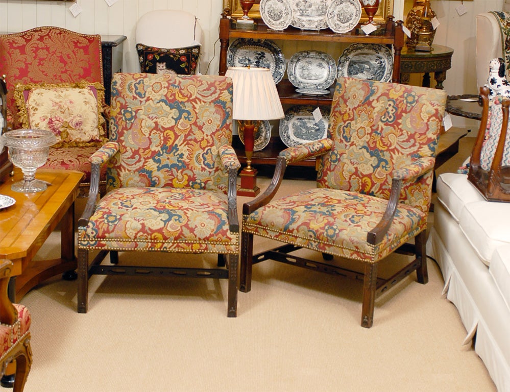 Pair 19th c. English Mahogany Chippendale Gainesborough Chairs with well carved arm and front leg detail. 