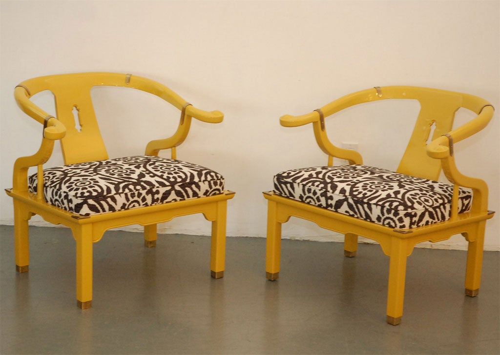 Pair of Asian chairs in the style of James Mont lacquered canary yellow with elegant black and white upholstry.  Great Hollywood regency style. Brass detailing.
