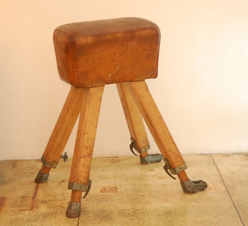 Brown leather pommel horse with wooden legs and aluminum capped feet.  Extremely heavy.  The legs can be cut to make this into bench height.