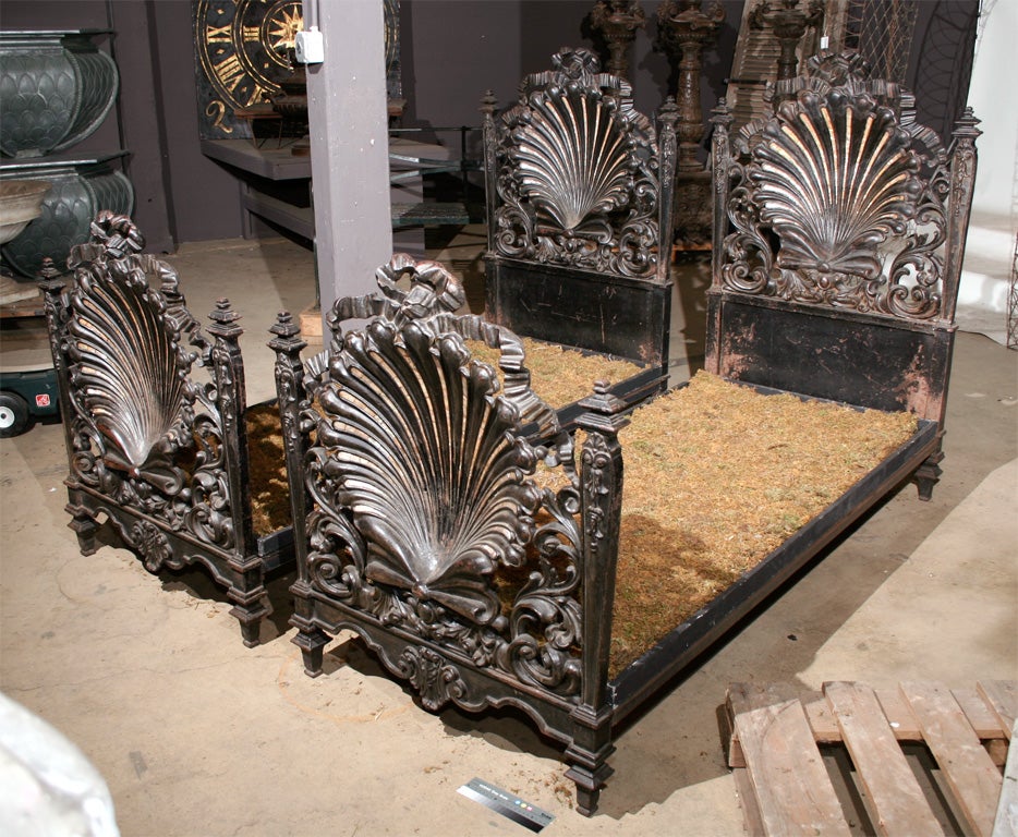 Fantastic pair of late 19th century Italian cast iron beds in the Rococo taste, the head and foot boards are three dimensional scallop shells with mother–of-pearl inlay, surmounted with bows and flowing ribbons, and surrounded by foliate scrolls.