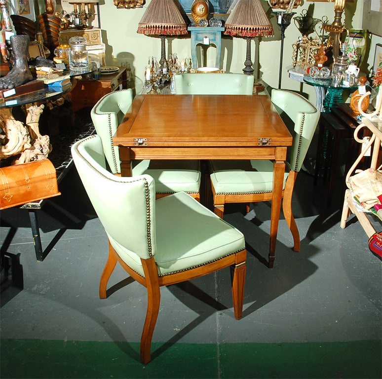 C. 1940-50 extension table with four upholstered chairs. The table first--it is made of pecan and is a 32 inch square till you open it up and it becomes 32 x 64. So it goes from small dining/game table to bigger dining table. Now the chairs--the