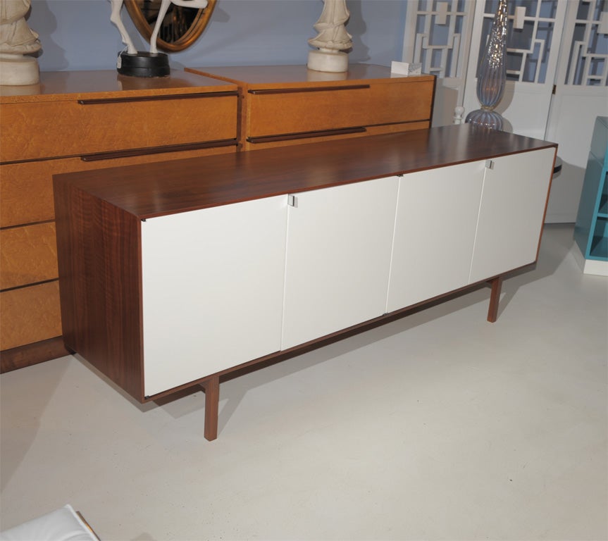 Florence Knoll designed credenza with black walnut case and white lacquered doors and fitted interior. Completely restored and labeled.