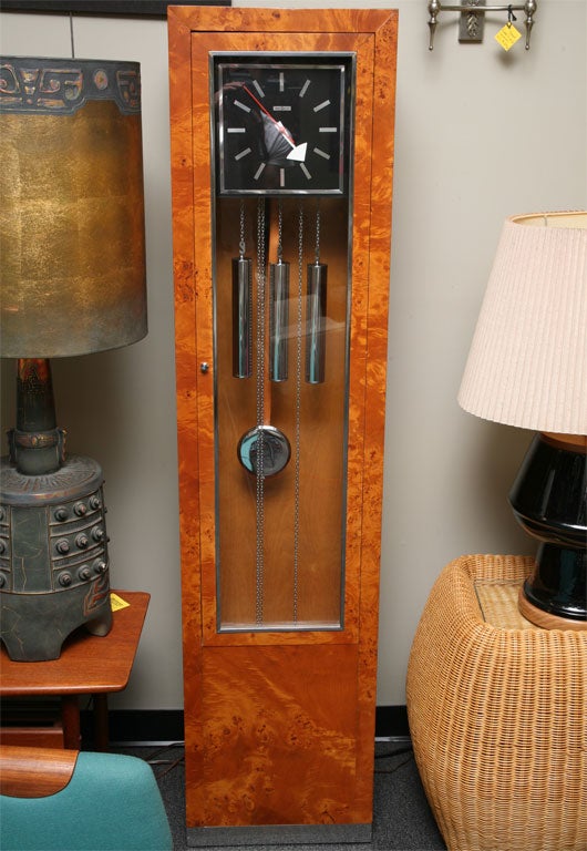 Rare find.  George Nelson Grandfather Clock with weight driven movement in a modern Burlwood cabinet made by Howard Miller. Features lovely soft Westminster chimes on every quarter hour.  Pull the chained chromed weights to wind weekly.  Chrome base