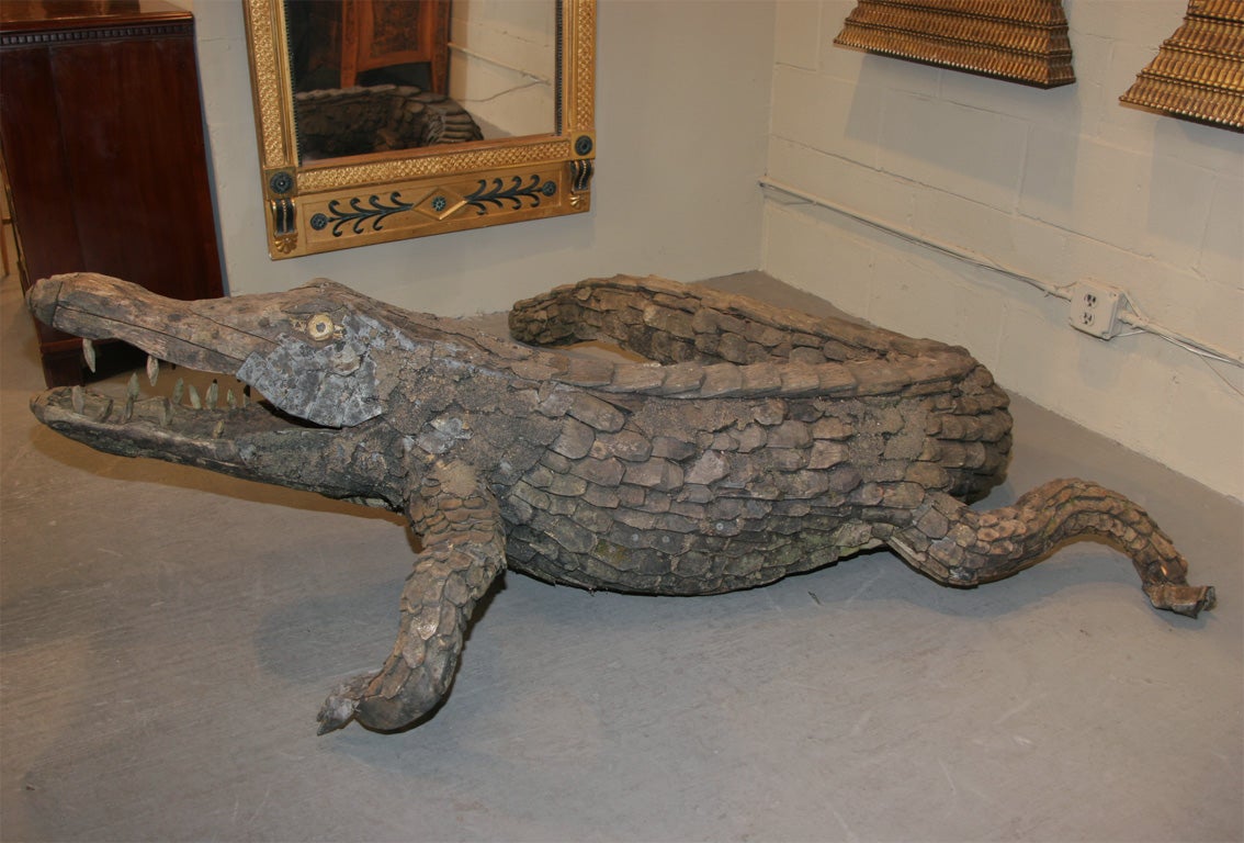 A carved and applied wood,tin and mortar alligator, found in Northern Sweden, Early 20th century<br />
<br />
72in.-back leg to tail tip.<br />
74in.-snout to back leg<br />
24in.-high