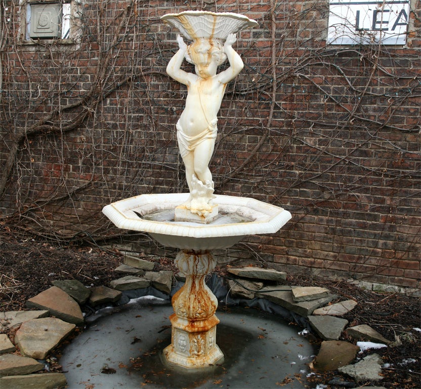 TWO TIER CAST IRON FOUNTAIN OF A CHERUB HOLDING A SHELL. ORIGINALLY PRICED$ 3,200.00