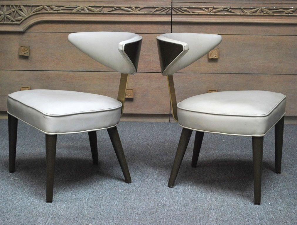Elegant pair of side chairs by Monteverdi-Young. The chairs are in a olive wood finish and have brass detailing to the backs and are upholstered in a soft Ivory leather.