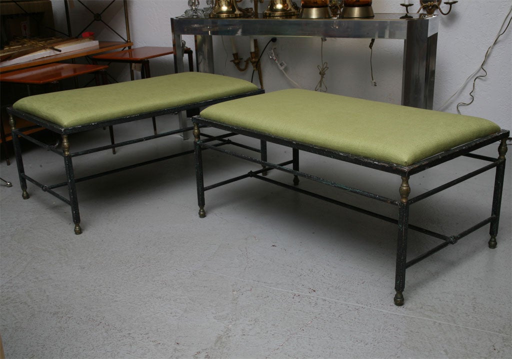 Pair of iron benches which can be used as seating or as coffee tables. The pair have recently been reupholstered in a green woven cotton.  They are versatile and sturdy.