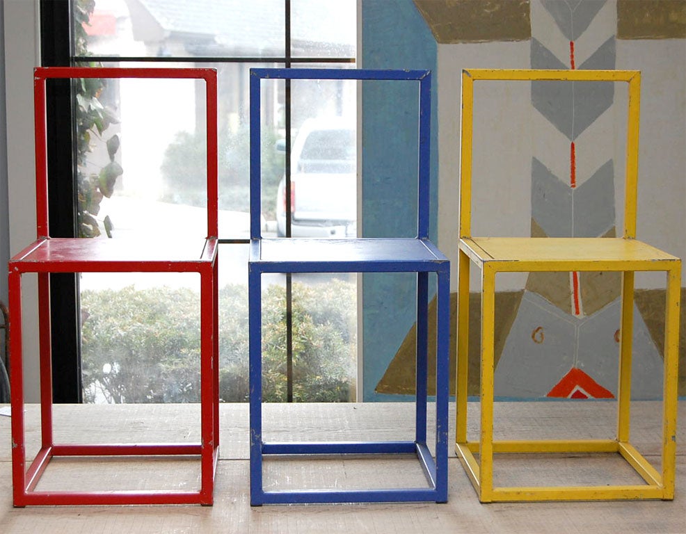 Three chairs in the style of Donald Judd. The set is painted in primary colors with metal frames and wooden seats. Great as a sculpture or for a kids room.