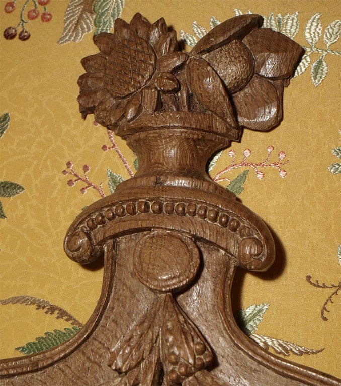 Hand carved from a single block the urn has a flat back. Ornamentation includes fan, half quadroons, swags ending with a sunflower at the crown