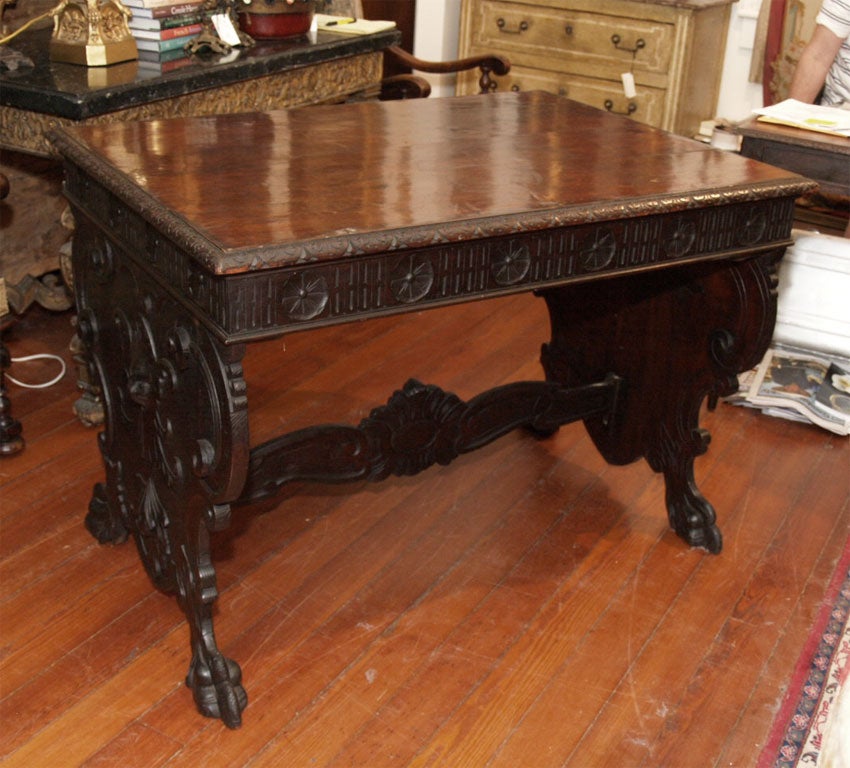 Italian Walnut Sofa Table or Desk with one drawer in a gadrooned top upon carved trestle legs and a carved stretcher.<br />
Wonderful carving and patina.