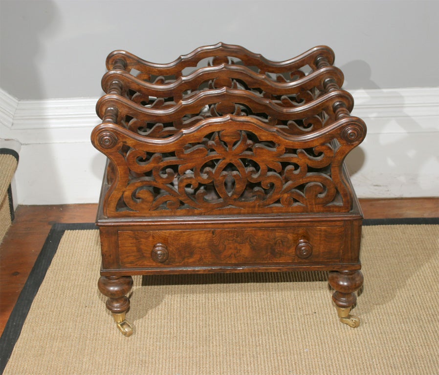 Fine English Figured and Burl Walnut Canterbury Music Stand, with four shaped fretwork dividers above a single mahogany lined drawer with turned knobs, on turned feet ending in brass toes and castors, circa 1870.

Height: 19