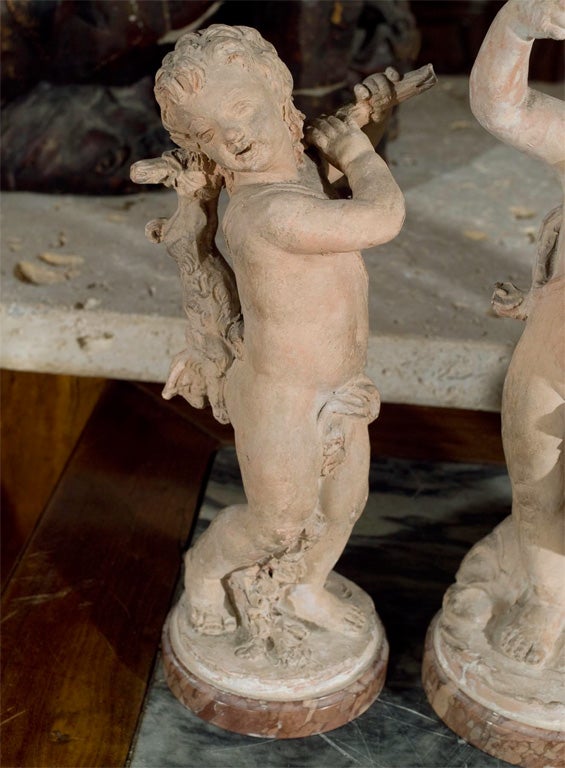4 terra cotta figures of putti, on marble bases, hand worked, dated on the backs 1735, but we believe them to be 19th century