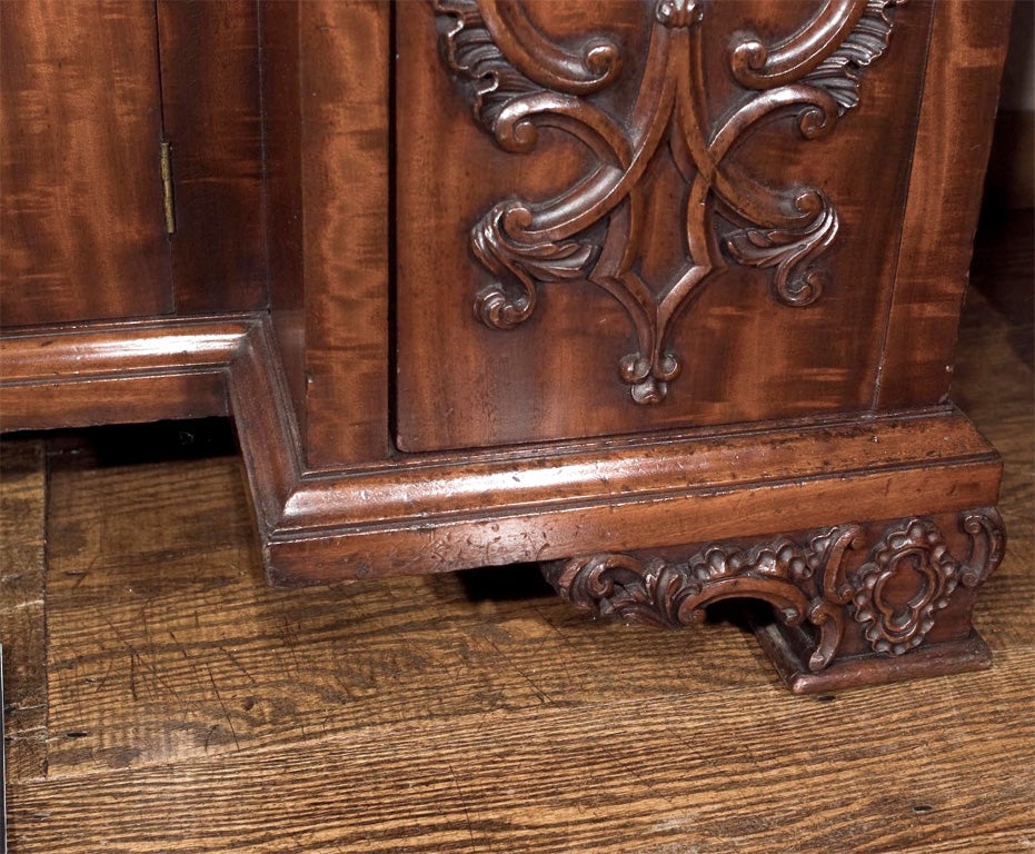 Chippendale style mahogany desk with deep relief work and appliques. Finely figured mahogany on the case and doors of this piece sets it apart from the crowd. The desk interior is veneered in a particularly rich satinwood and the writing surface is