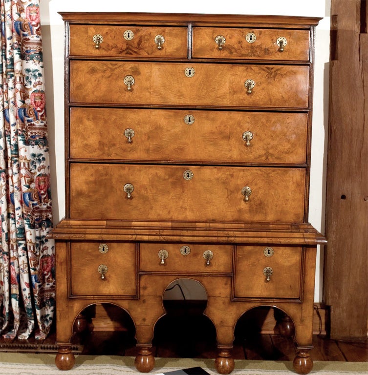This classically proportioned English walnut and walnut burl chest on stand with bun feet has everything in place. The herringbone crossbanded drawers with brass teardrop pulls, filigree backplates and escutcheons and the outstanding walnut grain