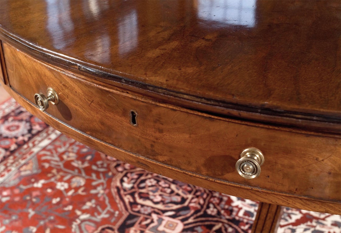 Mahogany large-scale drum table on large brass casters. Beaded drawers with brass knobs complete the Regency style of this table