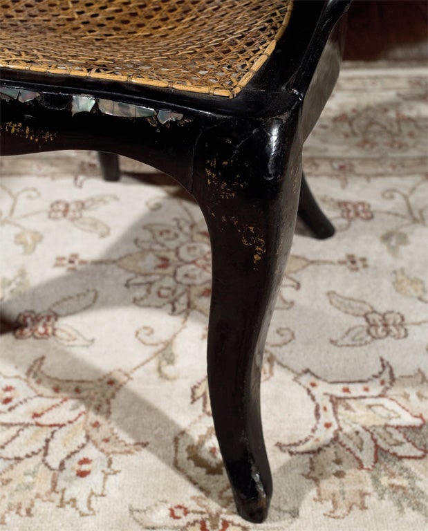 Black lacquer side chair with mother-of-pearl inlay, well executed painted flowers and caned seat.