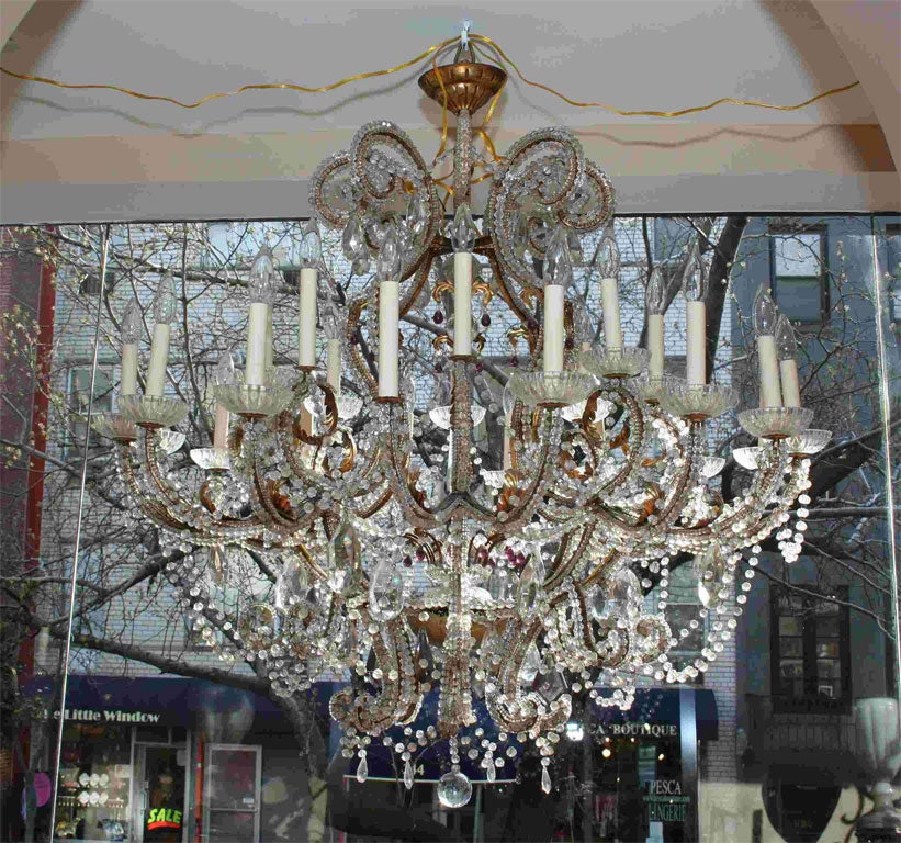 A circa 1900's French gilt metal beaded chandelier with lights,  with 24 lights in two levels. Clear beads with amethyst drops. Original patina.
Measurements:
Height: 48