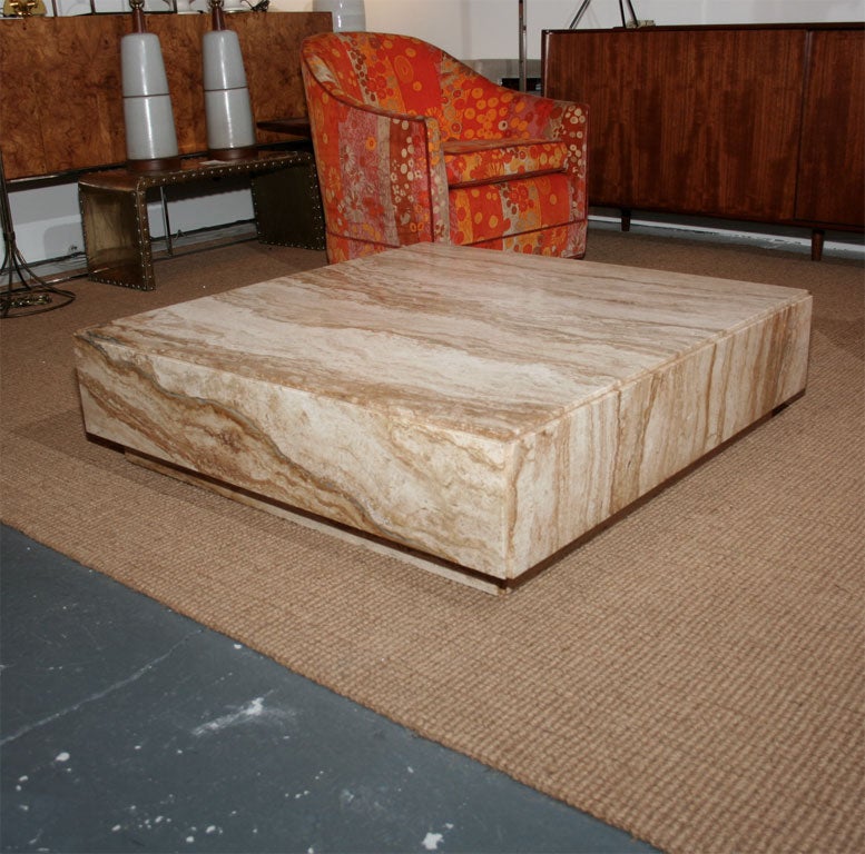 A dramatic travertine cocktail table raised on a stone plinth by Milo Baughman. American, circa 1970.