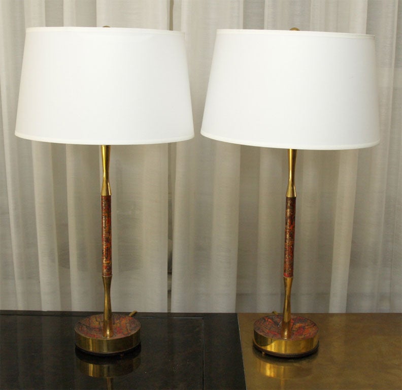 Lovely attenuated table lamps in brass with applied enamel in a modernist pattern; the base in a shallow bowl shape with brass edges; the stem in brass with applied enamel; shades for photos only.