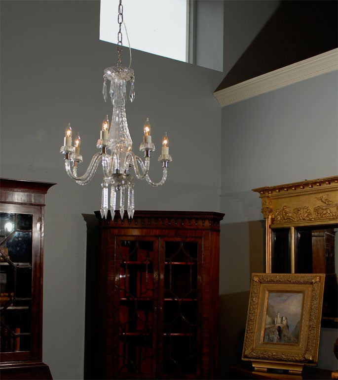 Exquisite signed Waterford six arm Deco style chandelier, having center column support, prisms on top and bottom, and silver hardware and trim.