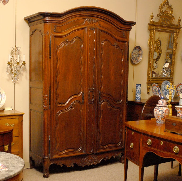 Armoire di epoca Luigi XV con piano Bonnet e grembiule sagomato, costruito in noce massiccio e risalente al terzo quarto del 1700. 

Di origine francese, probabilmente provenzale, è unico nel suo genere in quanto conserva la decorazione interna