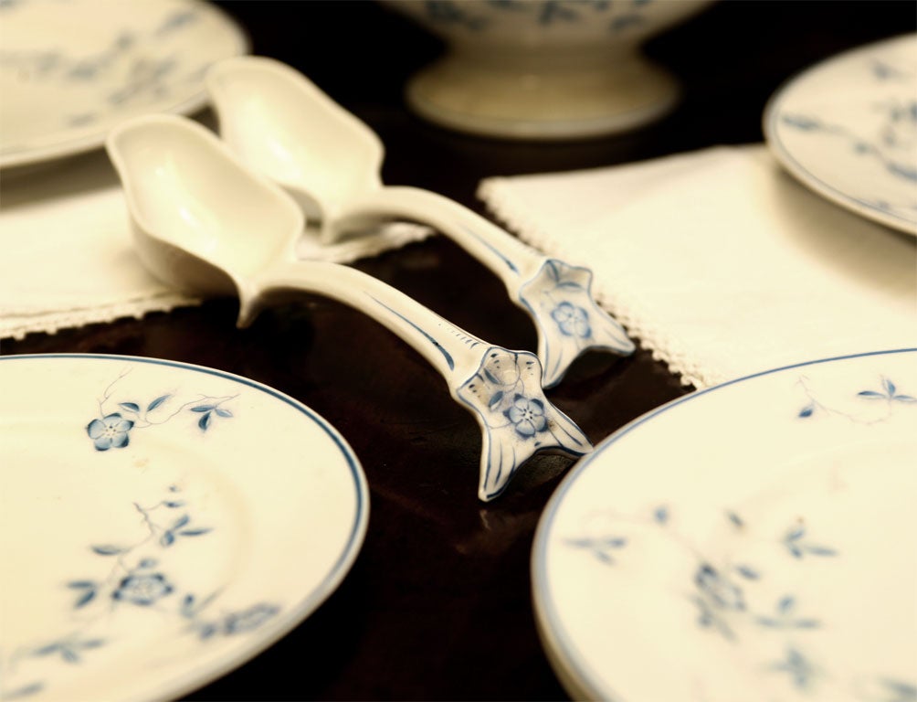 Large dinner service from England. Crisp white qround with dainty blue vine design. This set has wonderful finials and handles on the covered vegetables and small tureens. This is a nest of 5 graduated platters and pair of ladles. <br />
List