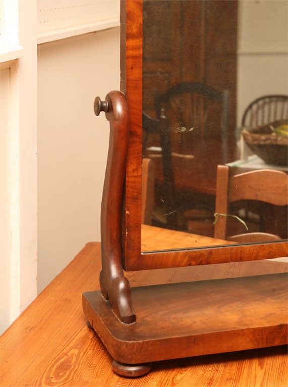 This Victorian shaving mirror is made of Mahogany. It will tilt forward or back to provide the best view. It has its original mirror and sits on four very squat bun feet