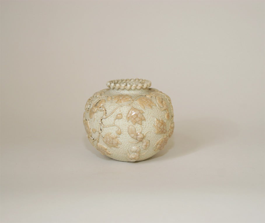 Small Globular vase creatively decorated with heavy, white glaze in high relief, depicting bats and fruits with foliage.