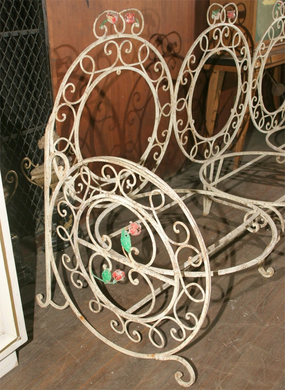 Fanciful 30's wrought iron settee with rose detail. Four matching arm chairs and a side table are available.