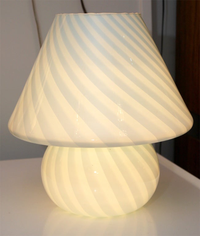 Very pretty light blue Murano artglass lamp. The lamp is designed with the classic silhouette of a lamp with shade, but is made entirely of glass. A swirling pattern completes the design.