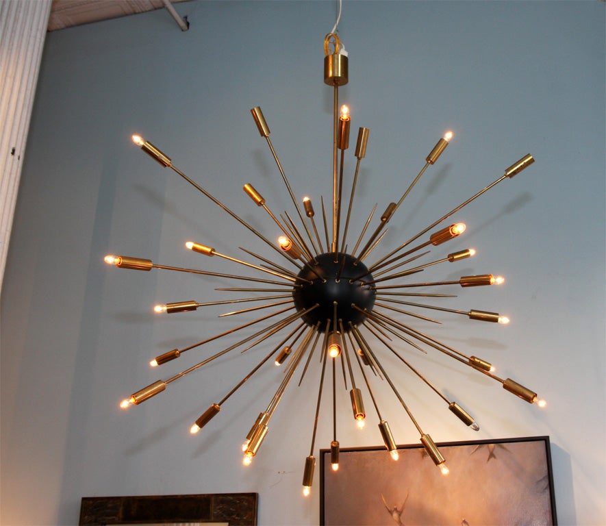 Impressive, large scale light fixture reminiscent of an exploding star.  Brass rods--both lit and speared--shoot out of a black steel core.  Very high-quality, hand made piece.
